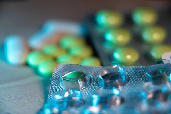 Empty pill package with pills in the background. Used pill packaging and loose tablets and pills