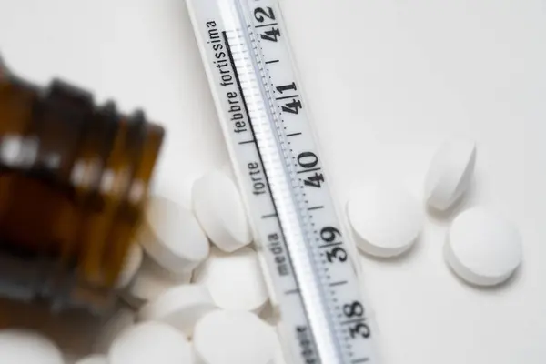 Higany Üveg Hőmérőben Fehér Felületen Gyógyszerekkel Tablettákkal Analóg Láz Lázmérő — Stock Fotó