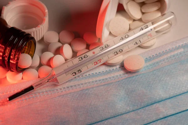 Lázmérő Kék Arcmaszkon Fehér Tabletták Gyógyszerek Klinikai Hőmérő Mögött Sebészeti — Stock Fotó