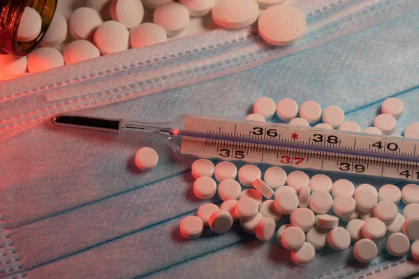 Celsius Lázmérő Arcmaszkon Gyógyszerekkel Körülvéve Kék Sebészeti Maszk Piros Lámpával — Stock Fotó