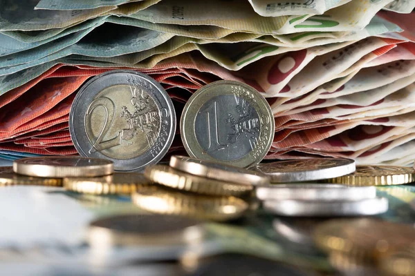 Euro coins next to each other, with bills in the background, European money currency. Money to pay rent or debt