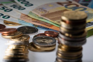 Euro banknotları 20 ila 200 Euro arası. Ön planda bozuk paralar odak dışı