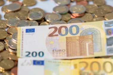 200 Euro banknot. Yeni ve eski banknotlar. Banknotların altında Euro sikkeleri. Merkez Bankası 'ndan Avrupa Nakiti. 200 Euro.