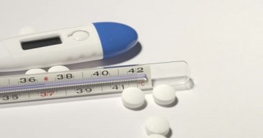 Beyaz yüzeyinde beyaz haplar olan ateş ölçer. İlaç, klinik termometre