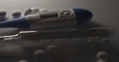 Klinik termometre ve karanlıkta haplar, gölgeler ve düşük ışık