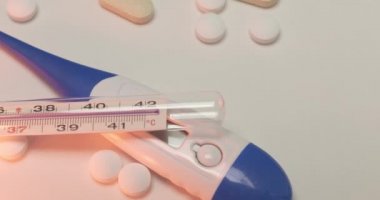 Parlak yüzeyde ateş ölçer ve haplar izole edilmiş tıp ve klinik...