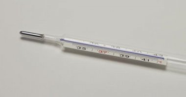 İzole klinik termometre, beyaz yüzeyde cam cıva termometre 4K 'da.