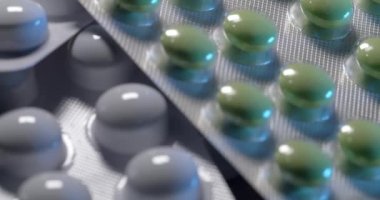 İlaç ambalajında ilaç. Masadaki hapları gevşetmek için. Ahşap yüzeyde sağlıkçılar. Yeşil ve beyaz haplar.