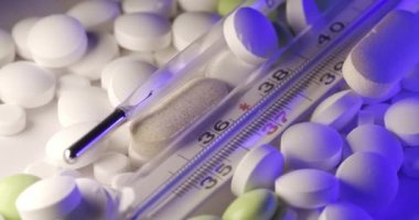 Ateşli termometre ve ilaç. Artan sıcaklıkla soldan sağa dönüyor. Viral enfeksiyonlar, antibiyotikler ve vitaminler için farklı ilaçlar.