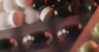 Farklı haplar ve vitaminler, kırmızı ve beyaz ışığın altında, koyu renkli kapsüller ve takviyeler. Farklı tıbbi durumlar için ilaç. Antibiyotikler, farklı şekillerde ağrı kesici.