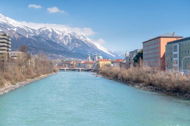 Innsbruck, Avusturya - 20 Mart 2019: Inn Nehri Innsbruck 'u geçerken köprüden, Arka plandaki Dağlardan ve nehir kıyısındaki binalardan görüldü