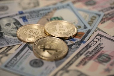 Dolar banknotlarındaki altın Bitcoin paraları. Amerikan doları banknotlarında altın kripto para. Dijital para ve fiziksel devlet para birimi.