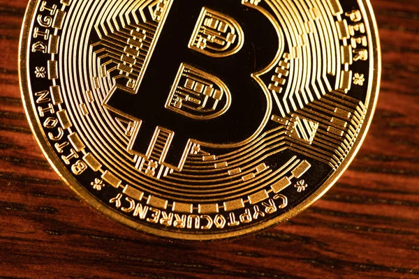 Bitcoin coin on wooder surface, golden crypto currency coin. Cryptocurrency concept. Bit coin closeup. Electronic money cash