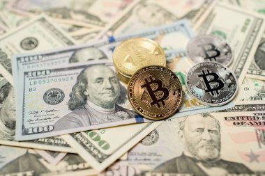 Bitcoin, ABD Doları Banknotlarının üstünde. Fiat para birimi ve Kripto para birimi konsepti. 100 Dolarlık banknotlar ve 50 Dolarlık banknotlarla altın ve gümüş BTC Paralar