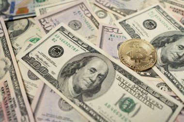 Altın Bitcoin paralar 100 dolarlık banknotların üstünde. Şifreli para ve Fiat para birimi. Dijital Para konsepti. Şifreleme ve Dolar Ticareti