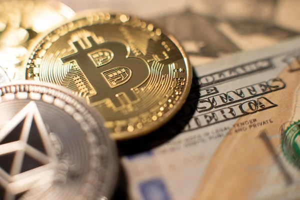 100 dolarlık banknotun üzerindeki ruhanî para. Arka planda altın Bitcoin var. Kripto dolar değişim konsepti