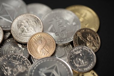 One dollar coin on half dollar and silver Bitcoin coins. Digital crypto currency Bitcoin, Ethereum and Litecoin with USD