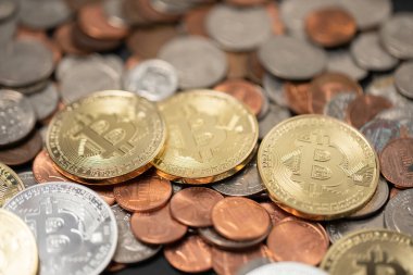 A pile of coins, US dollar coins next to Crypto coins. Gold and silver Bitcoins on top of copper pennies. Digital currency concept. trading USD with BTC