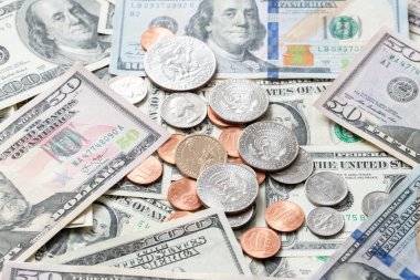 Dollar coins on banknotes from United States of America. US currency. Cash piled up money.