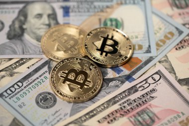100 dolarlık banknotların üstüne altın Bitcoin paralar. BTC 'den USD' ye. Amerika Birleşik Devletleri para birimi.