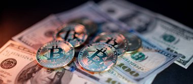 ABD 'den gelen 100 dolarlık banknotlara altın Bitcoin' ler. Kripto para birimi Bitcoin ile Amerika Birleşik Devletleri para birimi. Turuncu ve Beyaz ışıkla aydınlatılmış