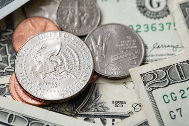 Half Dollar Coin on smaller coins surrounded by Dollar Banknotes. US Economy and Currency. Pile of Cash Money
