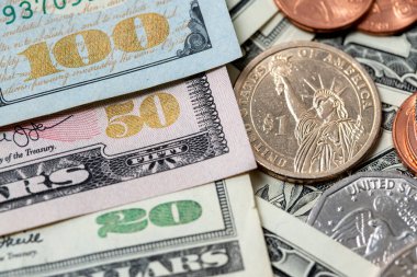 US Dollar Banknotes with shiny denomination numbers from twenty to one hundred USD, Banknotes next to Dollar coins, 1 Dollar coin