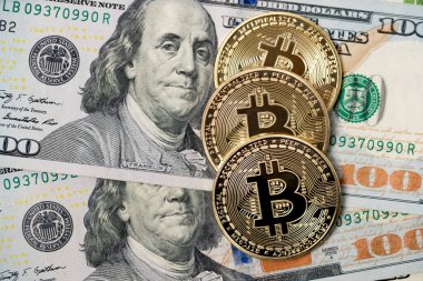 100 dolarlık banknotların üstüne altın Bitcoin paralar. BTC 'den USD' ye. Amerika Birleşik Devletleri para birimi.