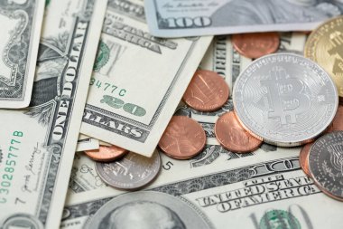 Dolar banknotları ve sikkeler üzerine gümüş Bitcoin. ABD Doları ve kuruşları olan dijital kripto para birimi. USD ile BTC ticareti