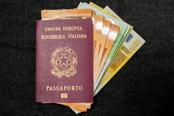 İtalyan pasaportu, Karanlık Arkaplanda Euro banknotlarıyla dolu. Seyahat kimliği ve nakit para. Avrupa Tatil için Seyahat Fonları