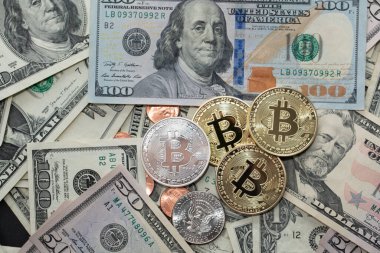Bozuk para ve banknotların yanında Bitcoin. USD paralı dijital şifreli para birimi. Blok zincir teknolojisi üzerinde şifreli para birimleriyle dolar değişimi..