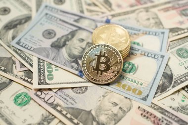 Amerika Birleşik Devletleri 'nden gelen 100 dolarlık banknotların üzerinde Bitcoin para var. Dijital kripto para birimi ve Amerikan doları. Yığınla paranın üzerinde altın parlıyor.