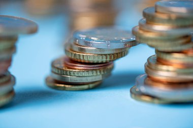 Mavi arka planda birikmiş paralar. Avrupa Birliği 'nden Euro sikkeleri. Para ve para kulelere yığıldı