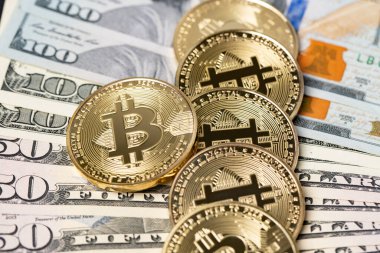 Elli ve yüz dolarlık banknotların üzerinde altın bitcoin paralar. Kağıt para ve dijital para. Kripto değişim konsepti