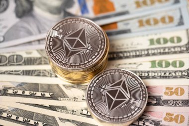 Ethereum 'un nakit parası. Arka planda 50 ve 100 dolarlık banknotlar olan Eter sikkeleri birikmiş. Kripto para ve ABD 'den gelen kağıt para.
