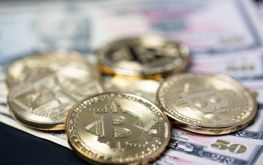 50 dolarlık banknotlarda Bitcoin altın sikkeleri. Dolar ile bitcoin kripto para birimi kavramını değiştir
