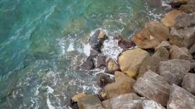 İtalya 'da Akdeniz' de kayaların üzerinde dalgalar kırılıyor. Okyanus dalgalarının hava görüntüsü