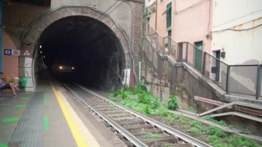 Vernazza, İtalya - 10 Haziran. 2021: Tünel 'den çıkan ve Vernazza' daki tren istasyonunu geçen yük treni. Yüklü yük vagonları.