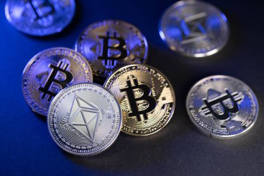 Koyu arkaplanda Gümüş Ethereum ve Altın Bitcoin sikkeleri. Blockchain Teknoloji kavramı