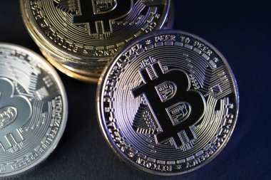 Koyu arkaplanda altın ve gümüş Bitcoin paralar