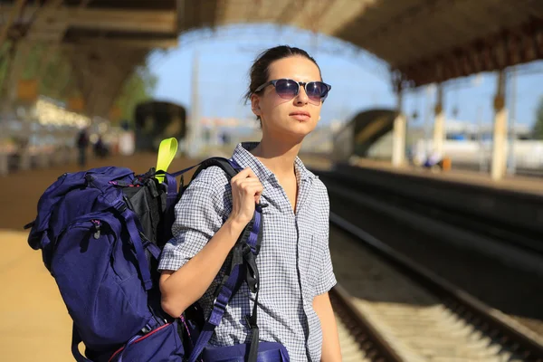 Backpackers flicka väntar på tåget — Stockfoto