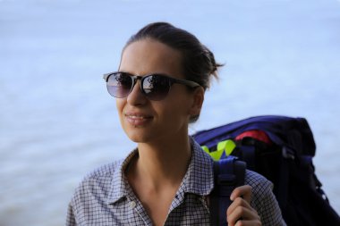 Deniz arka plan üzerinde bir sırt çantası ile kız