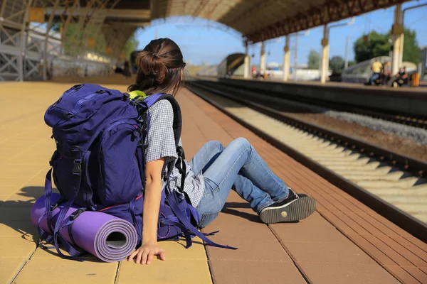 Backpackers flicka väntar på tåget — Stockfoto