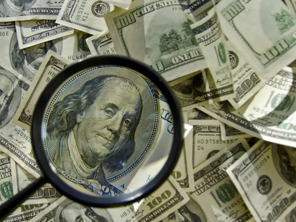 Bir yüz cam büyütme dolar, para, bir demet