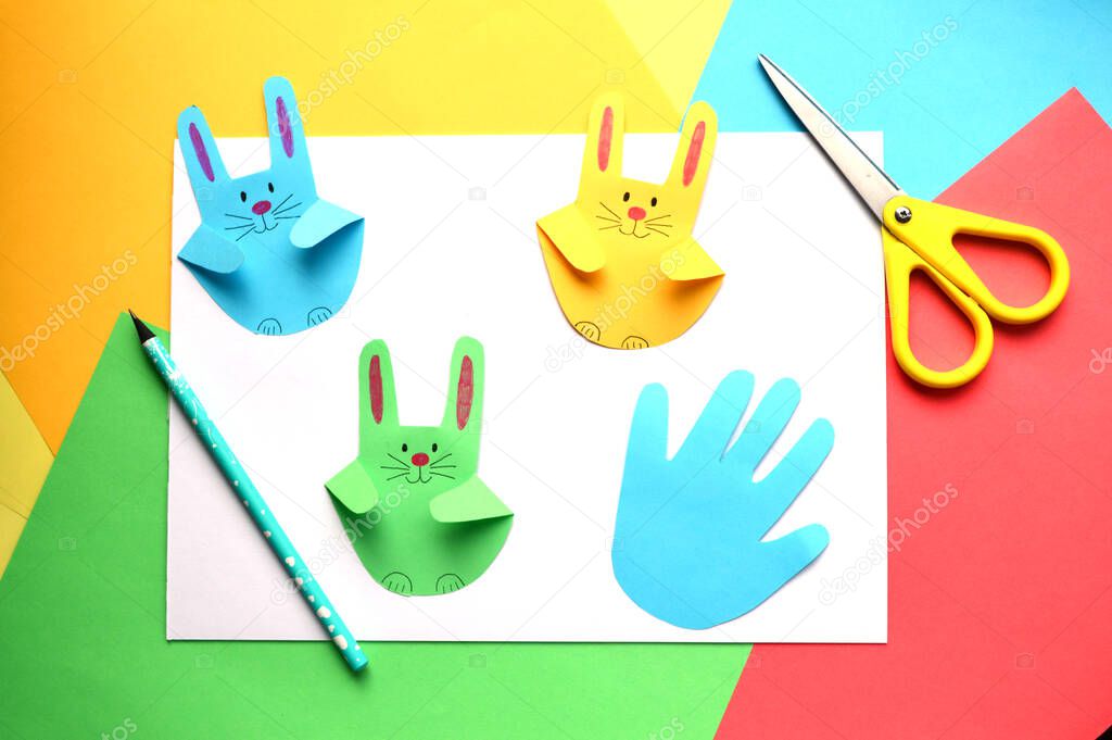 Easter crafts. Colorful paper bunnies from children's imprint of the palm of your hand
