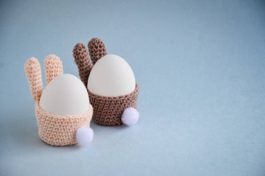 Paskalya tatili hazırlığı. Kuyruklu bir Paskalya tavşanı şeklinde örülmüş yumurta sepeti. Yumurta tavşancık şeklinde duruyor. Beyaz yumurta. Kartpostal Kendi ellerinle çocuklarla el sanatları yapıyorsun.
