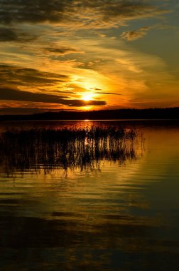 Gölde güzel bir gün batımı. Sudaki bulutların yansıması. Doğada yaz.