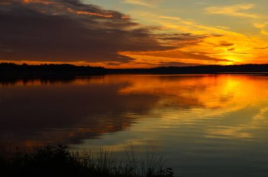 Gölde güzel bir gün batımı. Sudaki bulutların yansıması. Doğada yaz.