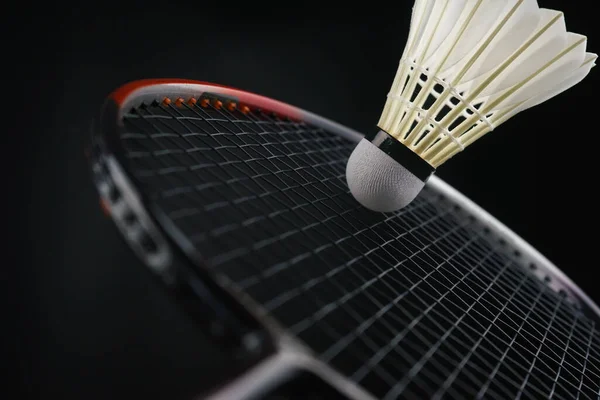 Badminton oyuncusu bir maçta badminton topuna vuruyor.