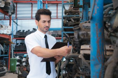 Kafkasyalı işletme müdürü fabrika deposunda ürünleri kontrol ediyor.